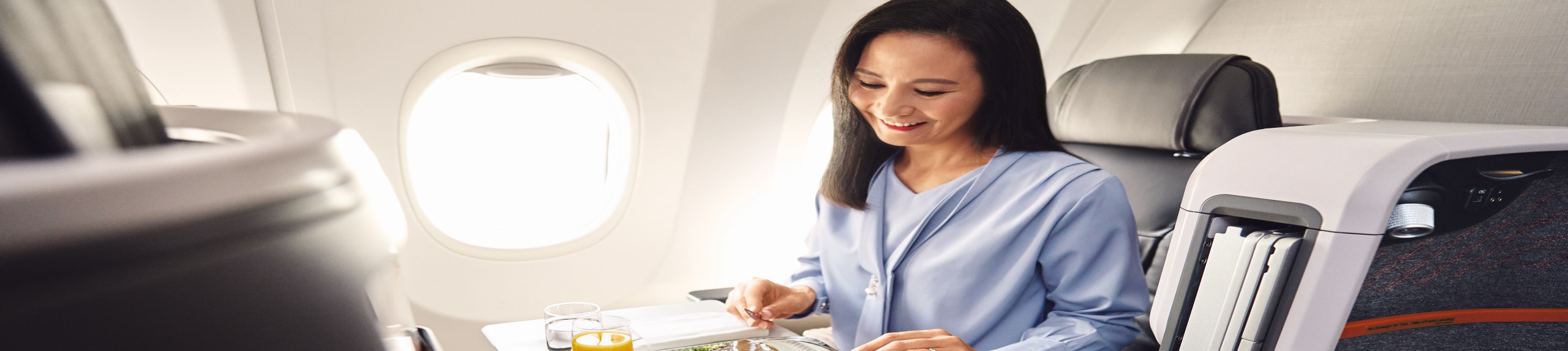 Passenger Enjoying Her Meal In Singapore Airlines Business Class